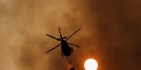 A helicopter works to extinguish a wildfire, in the area of Pico de las Nieves, on the Canary Island of Gran Canaria, Spain July 25, 2023. REUTERS/Borja Suarez     TPX IMAGES OF THE DAY