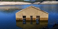 OURENSE, SPAIN - OCTOBER 27: One of the submerged Aceredo village buildings is seen emerged in the river Lima on October 27, 2021 in Lobios, Ourense, Spain.  The town of Aceredo has resurfaced during a low state of flow in the dam which was built 29 years ago and turned the valley into a reservoir. Some 250 people were forced to move to a village above the Lindoso reservoir and a church was moved to another town stone by stone, when the Portuguese state-owned EDP electricity company ran the Lindoso reservoir hydroelectric plant. (Photo by Octavio Passos/Getty Images)