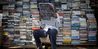 A book vendor reads a newspaper in Mumbai, India, on Tuesday, Nov. 6, 2012. Reserve Bank of India Governor Duvvuri Subbarao lowered the RBI’s forecast for India’s gross domestic product growth in the year through March to 5.8 percent, the slowest in almost a decade, from 6.5 percent. Photographer: Brent Lewin/Bloomberg via Getty Images