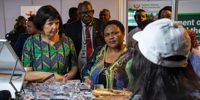 Forestry Fisheries and the Environment Minister Barbara Creecy (left) and Agriculture, Land Reform and Rural Development Minister Thoko Didiza listen to a vendor at the biodiversity economy exhibition. (Photo: Julia Evans)