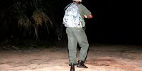 A member of SA National Parks anti-poaching unit patrols a river bank after nightfall in Kruger National Park. (Photo: Tony Carnie)