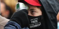 LANSING, MICHIGAN - OCTOBER 27: Supporters of U.S. President Donald Trump have their temperature taken as a precaution against the coronavirus before attending a campaign rally at Capital Region International Airport October 27, 2020 in Lansing, Michigan. With one week until Election Day, Trump is campaigning in Michigan, a state he won in 2016 by less than 11,000 votes, the narrowest margin of victory in the state's presidential election history.  (Photo by Chip Somodevilla/Getty Images)
