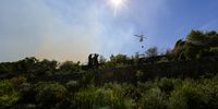 Residents watch a helicopter water bombing the vegetation fire on Tygerberg Hills. (Photo: Shelley Christians)