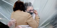 WANTAGH, NEW YORK - MAY 24:   Olivia Grant (R) hugs her grandmother, Mary Grace Sileo through a plastic drop cloth hung up on a homemade clothes line during Memorial Day Weekend on May 24, 2020 in Wantagh, New York.  It is the first time they have had contact of any kind since the coronavirus COVID-19 pandemic lockdown started in late February.  (Photo by Al Bello/Getty Images)