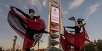 BEIJING, CHINA - OCTOBER 27: Women practice a dance routine in front of a large countdown screen showing 100 days before the opening of the Beijing 2022 Winter Olympics at the Olympic Park on October 27, 2021 in Beijing, China. The Games are set to open on February 4, 2022. (Photo by Kevin Frayer/Getty Images)