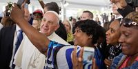 Cartrice Haynesworth, center, has a selfie taken with Pope Francis, left, as he walks through the crowd during a visit to Catholic Charities of the Archdiocese of Washington September 24, 2015 in Washington, DC. Pope Francis is in the United States for six days during his first trip as the leader of the Catholic Church. (Photo by David Goldman-Pool/Getty Images)