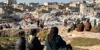 People watch rescuers and volunteers search for survivors under the rubble of collapsed houses, in Harim town near Idlib, Syria, 08 February 2023. More than 11,000 people have died and thousands more injured after two major earthquakes struck southern Turkey and northern Syria on 06 February. Authorities fear the death toll will keep climbing as rescuers look for survivors across the region.  EPA-EFE/KARAM AL-MASRI