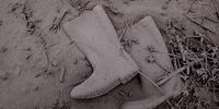 TIGA PANCUR, NORTH SUMATRA, INDONESIA - JANUARY 06: Shoes is seen covered by ash at the fields following a further eruption of the Mount Sinabung on January 6, 2014 in Karo District, North Sumatra, Indonesia. The number of displaced persons has increased to 20,000 in Western Indonesia as Mount Sinabung continues to spew ash and smoke after several eruptions since September. Eleven deaths have now been recorded as a result of the eruptions with hundreds more falling ill. Officials expect the number of evacuees to rise as volcanic activity remains high. (Photo by Ulet Ifansasti/Getty Images)