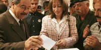 General Ali Hassan al Majeed, known as ‘Chemical Ali’ stands next to his wife during a referendum 15 October 2002 in Baghdad, Iraq.  (Photo: Oleg Nikishin / Getty Images)