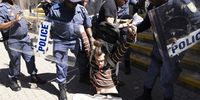 A protester is removed by members of the South African Police Force (SAPS) as activists from various civil organizations and supporters gather to protest in solidarity with Palestinians, at the head offices of the Department of Trade and Industry in Pretoria, South Africa, 21 August 2025. The protesters claim that the export of South African coal to Israel powers Israel's coal-powered power stations and this constitutes support of Israel's attacks on the Palestinian people.  EPA/Kim Ludbrook