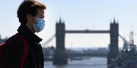 A masked man walks across the London Bridge in London, Britain, 23 March 2020.  EPA-EFE/ANDY RAIN
