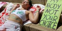 An abortion rights protestor lays on a sheet with the words 'woman not incubator' written on her stomach at the federal courthouse in Austin, Texas, USA, 22 April 2023. On 21 April the Supreme Court protected access to the abortion drug mifepristone, which will remain available for now.  EPA-EFE/Adam Davis