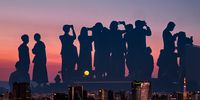 “People watching the full moon on the roof of a building.” In Japan, celebrating the beauty of the moon is a popular pastime called ‘moon viewing’ or Tsukimi. © Kaoru Sugiyama, Japan, 1st Place, National Awards, Street Photography, 2022 Sony World Photography Awards