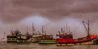 Massive waves crashing over fishing boats in Kalk Bay Harbour. Photographer: Martin Fennell