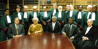 Formal picture of the original Judges of the Constitutional Court, together with Acting Judge Sir Sydney Kentridge, who acted on the Court when Richard Goldstone became First Prosecutor at the former Yugoslav War Crimes Tribunal at the Hague.Seated from left: Kobie Coetzee, Frene Ginwala, Nelson Mandela, Thabo Mbeki and Michael Corbett.<br>Standing from left: Yvonne Mokgoro, Richard Goldstone, Johann Kriegler, Ismail Mahomed, Arthur Chaskalson, John Didcott, Albie Sachs, Laurie Ackermann, Pius Langa, Sidney Kentridge and Tholie Madala. (Photo: thealbiecollection.org)