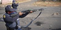 A member of the SAPS Public Order Police Unit fire rubber bullets into a crowd of residents in Eldorado Park, Johannesburg, South Africa on 27 August 2020. (Photo: Shiraaz Mohamed)