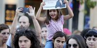 epa10208079 A child holds a sign with an image of Mahsa Amini that reads 'Solidarity with the women of Iran' during a protest, in Lisbon, Portugal, 26 September 2022. Mahsa Amini, a 22-year-old Iranian woman, was detained on 13 September by Iran's morality police and later died in custody.  EPA-EFE/MANUEL DE ALMEIDA