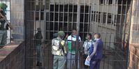 MDC alliance mp Job Sikhala, who was arrested on charges of inciting public violence, is seen at Harare Magistrate’s Court receiving some goods from his lawyers while escorted by prison guards. (Photo: Fazila Mahomed)