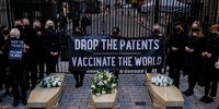 LONDON, ENGLAND - OCTOBER 12: Protesters pose for a photograph with cardboard coffins outside Downing Street during a protest against Covid-19 vaccine patents on October 12, 2021 in London, England. The protest, organised by Global Justice Now, called for an end to the UK's opposition to the suggestion that the World Trade Organization should suspend the enforcement of patents for the coronavirus vaccines to enable poorer countries to inoculate their populations.  (Photo by Rob Pinney/Getty Images)
