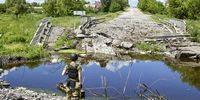 epa10016879 A Ukrainian serviceman inspects a damaged bridge in the Ruska Lozova village which was recently recaptured by Ukrainian troops in the Kharkiv area, Ukraine, 16 June 2022. Russian troops were recently pushed back by the Ukrainian army from the outskirts of Kharkiv city. On 24 February Russian troops had invaded Ukraine resulting in fighting, deaths and destruction and a humanitarian crisis in the country.  EPA-EFE/SERGEY KOZLOV