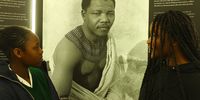 Ashleigh Naube (left) and Fadzaishe Sambumba (right), pupils from Central Park Primary School, stand in front of a photograph of a young Nelson Mandela at the ‘Nelson Mandela in Cape Town - Legacy Exhibition’ at Cape Town City Hall on 18 July. (Photo: Tamsin Metelerkamp)