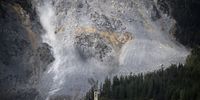 epa10998636 Rocks fall towards the village of Brienz/Brinzauls beneath the "Brienzer Rutsch", in Graubuenden, Switzerland, 12 May 2023. Two million cubic metres of rock from the mountain above the village are set to come loose and crash down to the valley in the imminent future.  EPA-EFE/GIAN EHRENZELLER