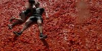 A couple kiss while covered in squashed tomatoes in the traditional tomato fight called 'Tomatina' in St. Petersburg, Russia 18 August 2019. The famous Spanish tomato battle 'Tomatina' was held for the first time at the 'Kirovets' stadium, where 20 tons of ripe tomatoes were used.  EPA-EFE/ANATOLY MALTSEV