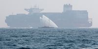 epa09246996 Cargo Ship 'Hamburg SOD (R) is seen in the background as Dhow boat 'Al Tabr' competing in the Al Gaffal Dhow Race outside Dubai, United Arab Emirates, 04 June 2021. Al Gaffal long distance Sur Bin Na'air 60ft Traditional Dhow Race (Dhow is a traditional boat) in Dubai is the biggest traditional sailing race in the world. 106 boats take part in the race which starts from Sur Bu Na'air Island to Dubai Eye at Bluewaters Island.  EPA-EFE/ALI HAIDER