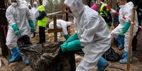 IZIUM, UKRAINE - SEPTEMBER 23: Rescue workers and forensic police exhume bodies from unidentified makeshift graves at the Pishanske cemetery on September 23, 2022 in Izium, Ukraine. A total of 447 bodies was exhumed from the gravesite, including 22 soldiers and 5 children, and the bodies will be examined by forensic officials for possible war crimes. In recent weeks, Ukrainian forces have reclaimed villages east and south of Kharkiv, as Russian forces have withdrawn from areas they've occupied since early in the war.  (Photo by Paula Bronstein/Getty Images)