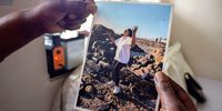 Linda Dewy holds up a photograph of her at the beach in Seapoint, the area she lived in before being evicted and moving to Ahmed Kathrada House. 26 June 2026. (Photo: Tamsin Metelerkamp)