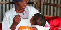 Nombembe Nolusapho Olivia (70), an old age grant beneficiary, feeds pap to her granddaughter at Chris Hani Park in Mthatha West, Eastern Cape. "Pap and bread are the only foods fortified with essential vitamins and micronutrients by legal requirement in South Africa."(Photo: Hoseya Jubase)