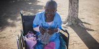 An old woman sits in her wheelchair enjoying the sun. Social isolation can have adverse health effects, including dementia. (Photo: Shiraaz Mohamed)