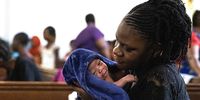 A woman tends to her week-old baby as African foreign nationals take refuge in the Central Methodist Church, Cape Town, on 7 January 2020. (Photo: EPA-EFE / Nic Bothma)