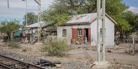 A woman sits outside her home in the impoverished community of Leeu-Gamka, in the Western Cape. (Photo: Victoria O’Regan)