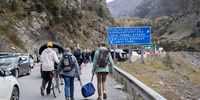 Travelers walking on the road from Verkhni Lars customs checkpoint between Georgia and Russia on September 28, 2022 in Zemo Larsi, Georgia. On September 21, President Putin announced what he described as a partial mobilisation of Russian army reservists to fight in Ukraine with 300,000 men to be called up and since then Russians have been fleeing to neighbouring countries. (Photo by Daro Sulakauri/Getty Images)
