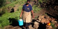 Mammofeng Sejanamane after filling her bucket with water from an unprotected well in Thabaneng village. (Photo: Sechaba Mokhethi)