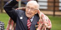 In this handout image provided by Capture the Light Photography, Colonel Tom Moore and his daughter Hannah celebrate his 100th birthday, with an RAF flypast provided by a Spitfire and a Hurricane over his home on April 30, 2020 in Marston Moretaine, England. Colonel Moore, formerly a Captain, received a promotion in honour of his 100th birthday and in recognition of the funds, in excess of £29m, he raised for the NHS by walking laps of his garden. (Emma Sohl - Capture the Light Photography via Getty Images)