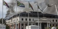 Firefighters battle a blaze on the roof of the National Assembly building as smoke billows from a fire flare-up at the South African Parliament National Assembly building in Cape Town, South Africa. 3 January 2022. (Photo: EPA-EFE/Stringer)