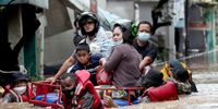 epa09618973 Indonesian national police wade through flood water as they rescue residents in Jakarta, Indonesia, 20 February 2021. At least 21 areas flooded following heavy rains, during which thousands of homes were damaged in the capital, according to the National Board for Disaster Management (BNPB).  EPA-EFE/Bagus Indahono