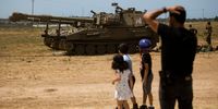 Israeli man and his kids look at Israeli tanks after Israel and Hamas agreed on a ceasefire on May 21, 2021 in Sderot, Israel. Yesterday, Israel's cabinet and Hamas, the militant group that rules Gaza, agreed on a ceasefire starting in the early hours of this morning. The recent fighting began on May 10th after rising tensions in East Jerusalem.  (Photo by Amir Levy/Getty Images)