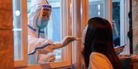 epa10154645 A medical worker takes a swab sample from a woman in Beijing, China, 02 September 2022. China has put the southwestern city of Chengdu, home to 21 million people on lockdown as preventive measures against COVID-19 as over 600 asymptomatic cases were recorded since last week.  EPA-EFE/WU HAO