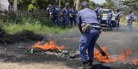 Police clear burning tyres at Tshepong Hospital in Klerksdorp on 7 March 2023 as Nehawu members picket outside the hospital. (Photo: Felix Dlangamandla)