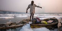 DELHI, INDIA - NOVEMBER 09: Fishermen anchor their boat along the shores of the River Yamuna amid the toxic foam caused by the pollution in the water as they return from a fishing trip on November 09, 2021 in Delhi, India. (Photo by Anindito Mukherjee/Getty Images)