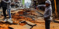 Residents stand along the road that collapsed following an explosion in Johannesburg's CBD on 20 July 2023. (Photo: Gallo Images / OJ Koloti)