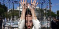 An Israeli activist performs as a hostage inside a cage during a women's march calling for the immediate release of all the hostages held by Hamas in Gaza, in Tel Aviv, Israel, 19 January 2024. According to the Israeli military, 133 Israelis, who were abducted and taken to the Gaza Strip during the 07 October 2023 attacks by Hamas, remain in captivity.  EPA-EFE/ABIR SULTAN