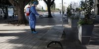 A public worker wearing protective gear sprays disinfectant on a public square as a precaution against the spread of the coronavirus in central Nicosia, Cyprus, 24 March 2020. (Photo: EPA-EFE / Katia Christodoulou)