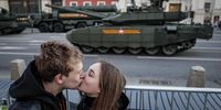 epaselect epa09926898 A young couple kisses in front of Russian heavy weapons at Tverskaya street, during the rehearsal of the Victory Day parade in Moscow, Russia, 04 May 2022. Victory Day is held annually on 09 May and marks the defeat of Nazi Germany in 1945.  EPA-EFE/YURI KOCHETKOV