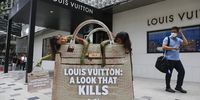 epa10321709 A man (R) looks at People for the Ethical Treatment of Animals (PETA) activists, with body-painted as pythons, sitting inside mock bloody Louis Vuitton handbag outside Louis Vuitton store in Kuala Lumpur, Malaysia, 23 November 2022. 'PETA investigation into Indonesian farms that supply snakeskin to Louis Vuitton, revealing  workers bashing snakes in the head with hammers, suspending them in the air, pumping them full of water and cutting off their skin, likely while they are still conscious', according to PETA statement.  EPA-EFE/FAZRY ISMAIL