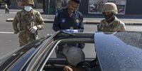 epa08326164 South African National Defense Force (SANDF) soldiers and a Metro Police officer check movement of a motorist at a roadblock during day 1 of a 21 day national total lockdown, in Cape Town, South Africa, 27 March 2020. The South African government is enforcing a 21 day total lockdown to try stem the spread of the coronavirus SARS-CoV-2 which causes the Covid-19 disease.  EPA-EFE/NIC BOTHMA