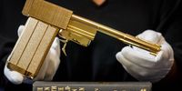 LONDON, ENGLAND - AUGUST 14: A limited edition replica of the gun from the film ‘The Man with the Golden Gun’ (estimate £6,000 - £9,000) alongside a first edition book with rare binding of ‘The Man with the Golden Gun’ (estimate £4,000-£6,000) are displayed on August 14, 2022 ahead of Sotheby's 'James Bond on Bond Street' auction in London, England. The auction will take place from 1st-6th September, and features over 100 items relating to Ian Fleming's enduring creation, in celebration of the 60th anniversary of the first James Bond film 'Dr. No'. Displayed at Sotheby's New Bond Street galleries, and offered for online bidding, the sale heralds the early years of Bond at his most classic, focusing on the era of Sean Connery and Roger Moore. (Photo by Tristan Fewings/Getty Images for Sotheby's)